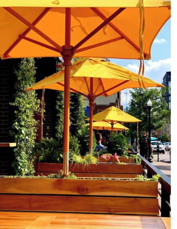 An outdoor seating area with wooden benches and yellow umbrellas.