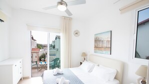 A hotel room with a bed, a desk, a chair, and a balcony with a view. - Protaras Holiday Villa Kv60 (Pernera)