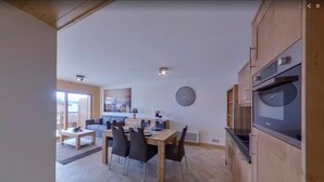 Et moderne køkken med spiseplads, træskabe og en stor ovn.