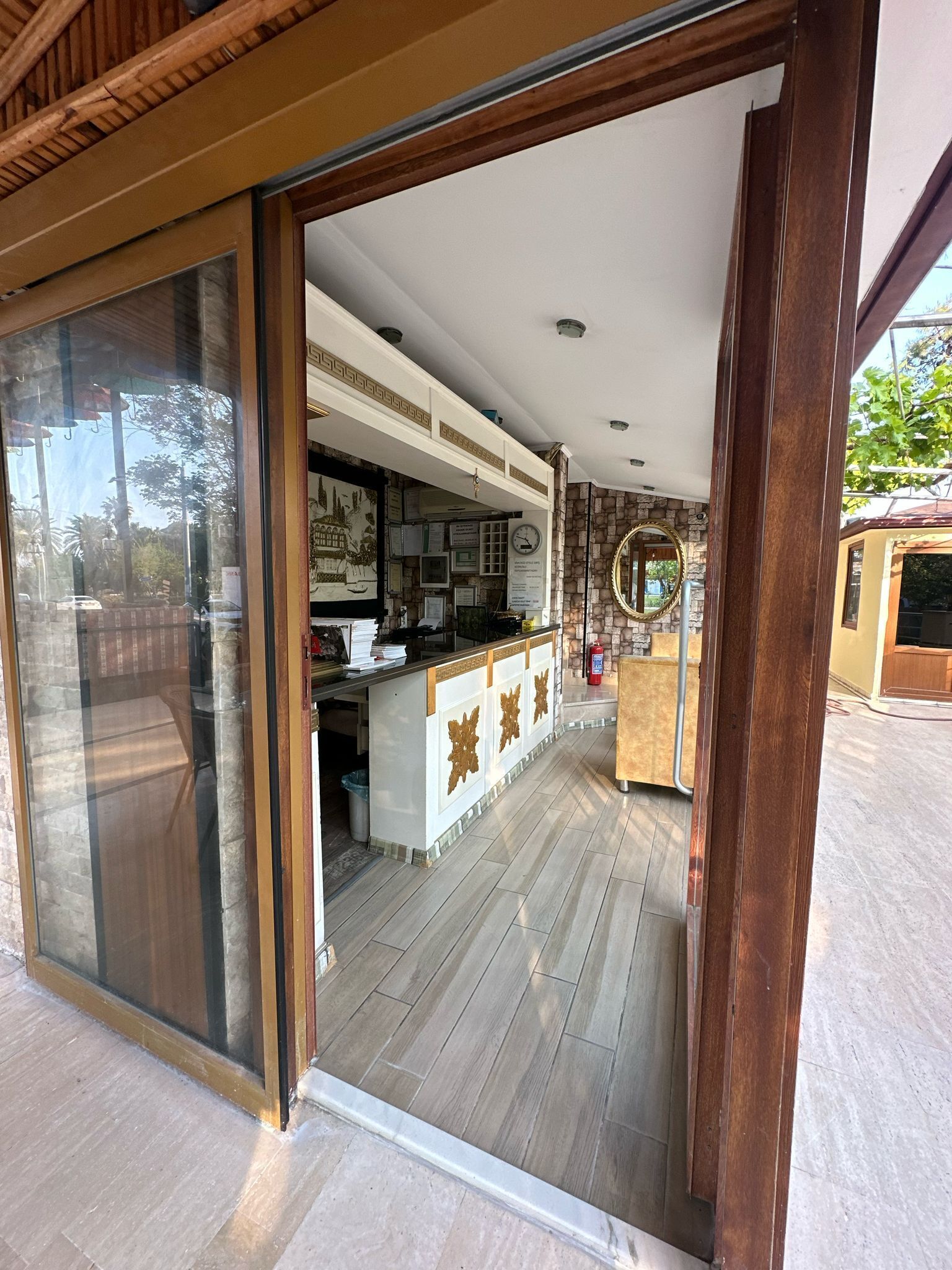 A modern kitchen with a central island, a stone accent wall, and a large mirror.
