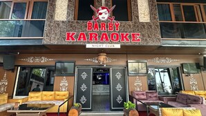 A bar with a sign reading "Barby Karaoke" and a night club sign. There are multiple colorful umbrellas hanging from the ceiling. - Barby Butik Otel (Kemer)