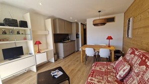 A compact living space with a kitchenette, dining area, and seating area.
