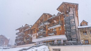 Et hotel med flere etager, balkoner og en svævebane.