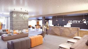 A modern hotel lobby with a reception desk, seating area, and a fireplace. - Wifi, swimming pool, terrace, balcony, tv, ski locker, 43-61m², Samoëns (Samoëns)