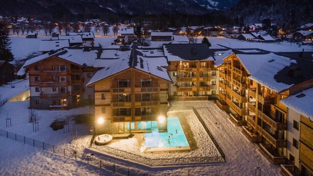 A snow-covered resort with multiple buildings, a central pool, and a mountainous backdrop. - Wifi, swimming pool, terrace, balcony, tv, ski locker, 43-61m², Samoëns (Samoëns)