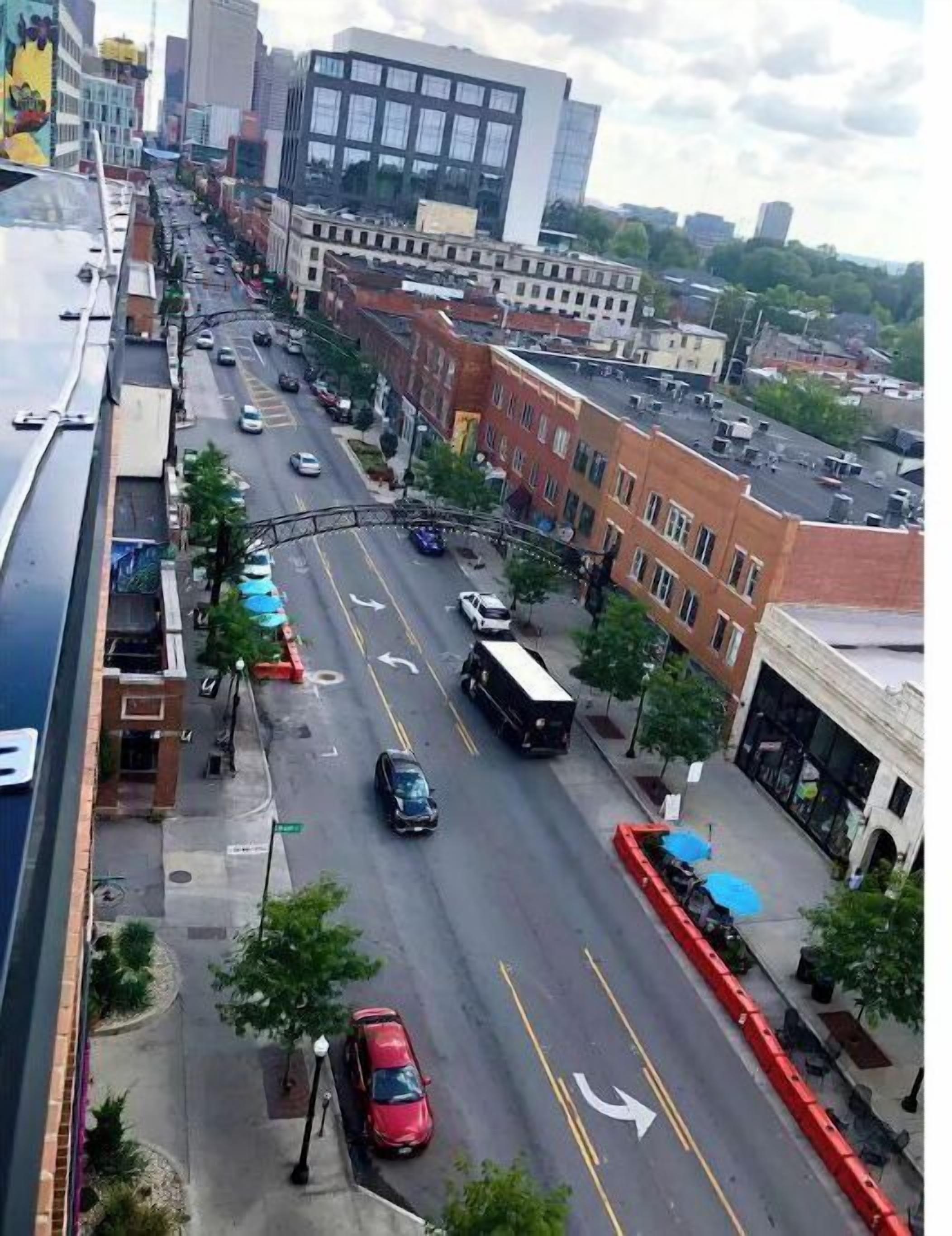A city street with buildings, cars, and a bus.