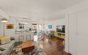 A modern apartment with a kitchen, dining area, and living room.