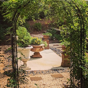 A garden pathway with potted plants and a gravel border.