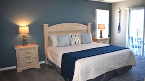 A bedroom with a bed, two bedside tables, and a window.