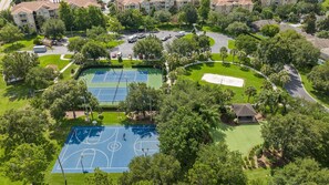 Vista aérea de uma área residencial com quadra de tênis, campo de golfe e edifícios de apartamentos.