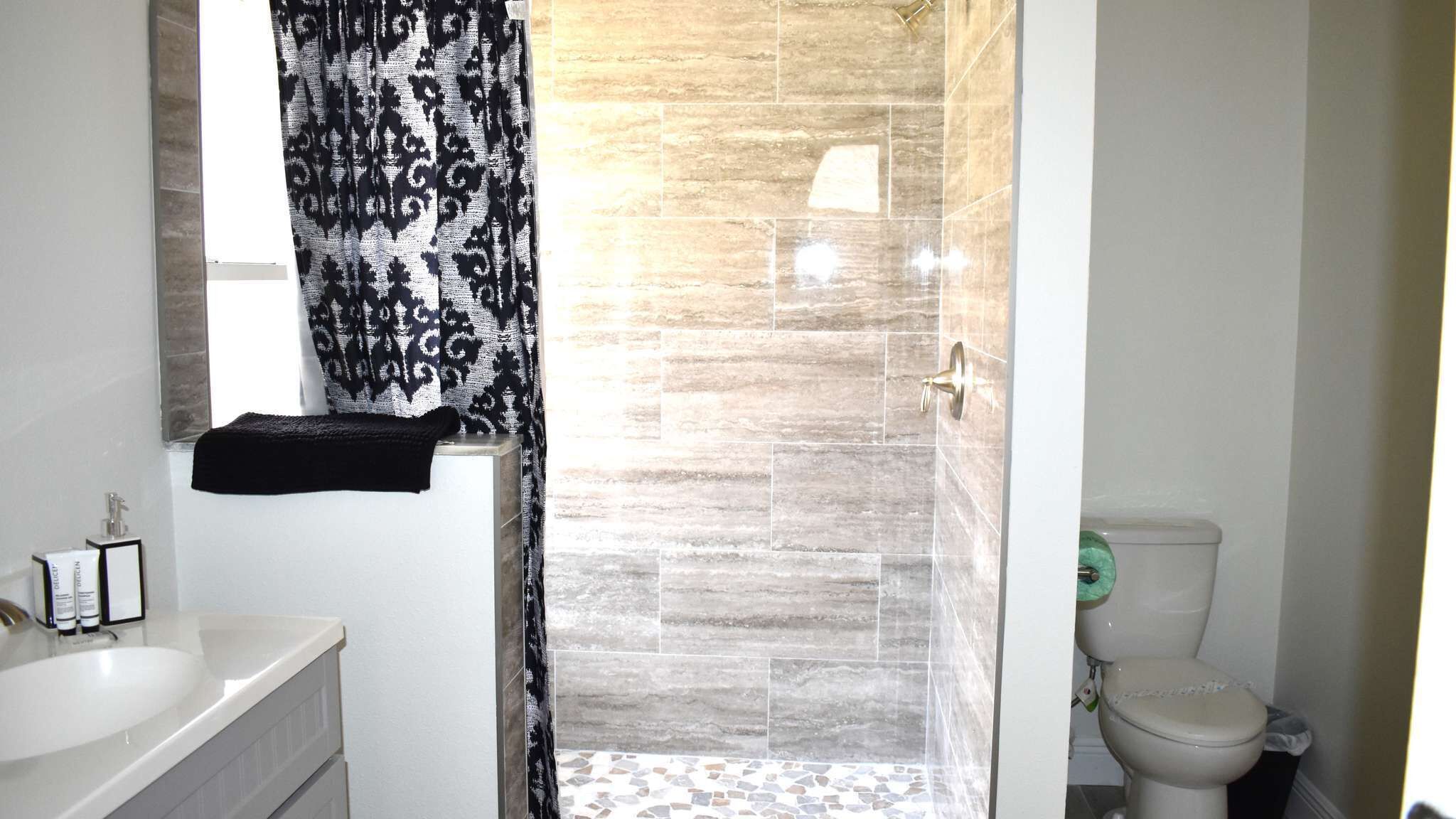 Un baño con ducha, inodoro y lavabo.