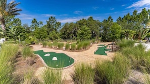 A miniature golf course surrounded by tall grass and trees. - Resort Home, private pool, gated community, great location! (Davenport)