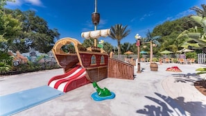 A pirate-themed play area with a slide, a ship-shaped play structure, and a small green frog statue. - Resort Home, private pool, gated community, great location! (Davenport)