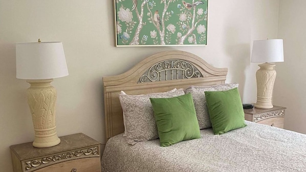 A neatly arranged bedroom with a bed, two nightstands, and two lamps.