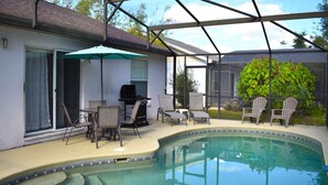 Et poolområde med overdækket terrasse, grill og stole.