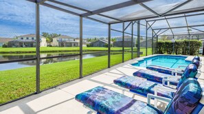 Área de piscina ao ar livre coberta, com espreguiçadeiras e vista para um bairro residencial.