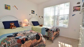 A bedroom with two beds, each with a distinct cartoon-themed bedspread. - Family pool home on gated community, private pool & jacuzzi, grill, games room. (Kissimmee)