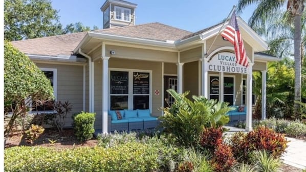 Um edifício de dois andares com uma placa que diz 'Lucaya Village Clubhouse'.