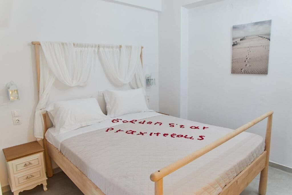 Una cama bien hecha con una colcha blanca y un mensaje escrito en rojo.