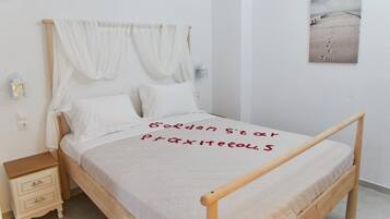 Una cama bien hecha con una colcha blanca y un mensaje escrito en rojo.