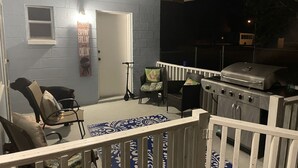 A covered patio with a grill, seating, and a scooter. - 2 Minutes to Downtown Crystal River, Large Fenced Yard, Boat Ramp, Pets OK ! (Crystal River)