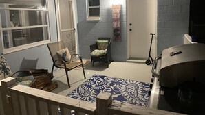 A covered patio area with a grill, a chair, and a scooter. - 2 Minutes to Downtown Crystal River, Large Fenced Yard, Boat Ramp, Pets OK ! (Crystal River)