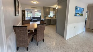 A spacious kitchen with a dining area, featuring a granite countertop, wicker chairs, and a ceiling fan. - 2 Minutes to Downtown Crystal River, Large Fenced Yard, Boat Ramp, Pets OK ! (Crystal River)