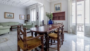 Un coin repas avec une table et des chaises en bois, un vase rempli de fleurs et un tableau accroché au mur.