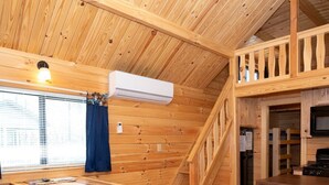 A wooden cabin interior with a kitchen, dining area, and a staircase. - 126) Zonetail Log Cabin. Close to Hocking Hills State Park and more! (Logan)