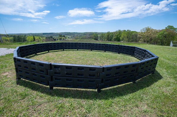A circular outdoor seating area made of black plastic furniture.
