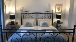 A neatly made bed with a metal headboard, two bedside tables with lamps, and a framed picture on the wall. - Stylish designer vacation apartment 2, 81sqm, WLAN, SAT, 1st floor (Monschau)