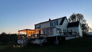 A two-story house with a covered porch and a small deck. - Have an unforgettable getaway at a family sized beach house with private beach! (Steuben)