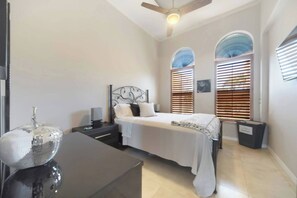Cozy retreat with a bed, bedside table, and ceiling fan.