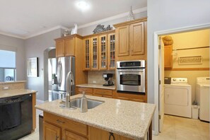 Enjoy cooking in this well-equipped kitchen with a central island, double oven, coffee maker, and dishwasher.