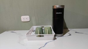 A white marble countertop with a KEURIG coffee maker and a tray with green mugs. - Family Studio with all the comforts, centrally located. (Jalapa)