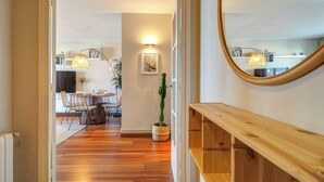 A hallway leading to a dining area with a wooden bench and a potted plant. - Balmins Surf by Hello Homes Sitges (Sitges)