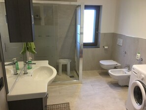 Een douche, een haardroger, een bidet, handdoeken