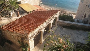 A coastal building with a tiled roof overlooking the sea. - Apartment Račić (Bol)