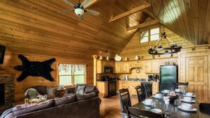 L’intérieur chaleureux d’un chalet en bois comprend un coin repas, une cuisine et un salon.