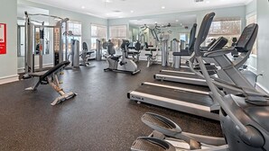 Ein Fitnessstudio mit Laufbändern, Kraftgeräten und Kurzhanteln.