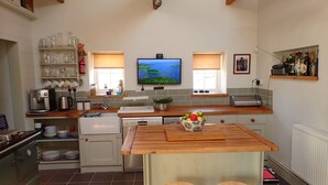 A modern kitchen with a wooden island, built-in appliances, and a large window.
