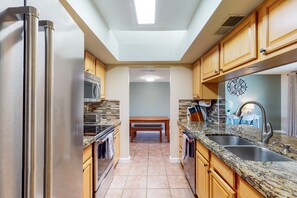 Enjoy cooking in this well-lit kitchen with a double sink, microwave, and oven.