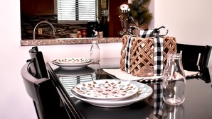 A dining table with plates, a glass bottle, and a wicker basket with a checkered ribbon.