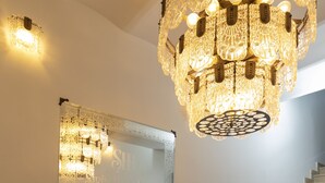 Ein prächtiger Kronleuchter, ein großer Spiegel und eine Treppe in der Hotelhalle.