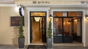 Das Hotel Sirin Han mit einer Treppe zum Eingang, einer Fußmatte mit dem Namen des Hotels und zwei Blumentöpfen.