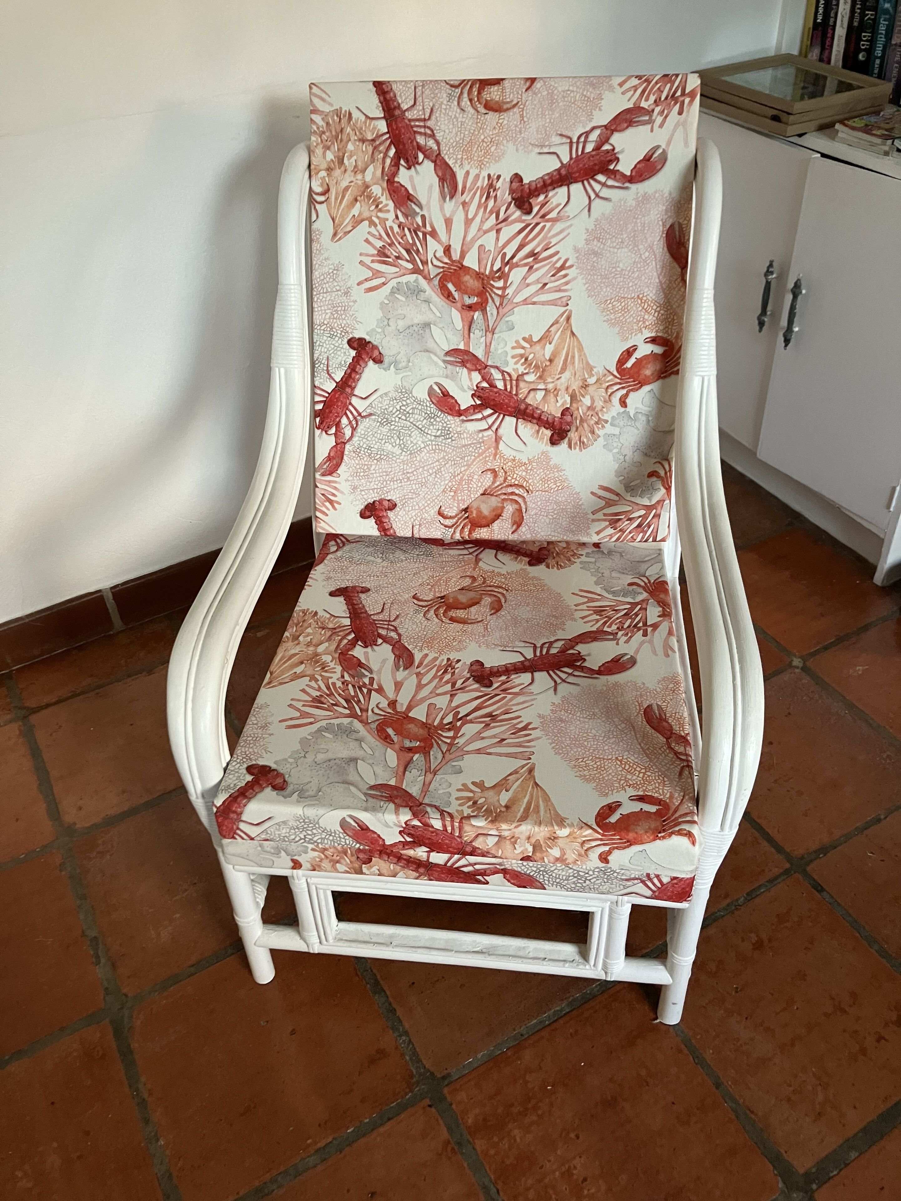 Een witte stoel met een bekleding met bloemen en krabben.