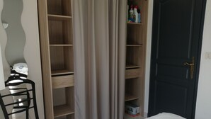 Un dormitorio con una cama, un escritorio y un armario.