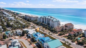 A coastal hotel with multiple buildings, a beach, and a clear view of the ocean.