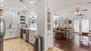 Una cocina moderna con armarios blancos, electrodomésticos de acero inoxidable y una isla central.