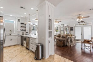 A modern kitchen with white cabinetry, stainless steel appliances, and a central island.
